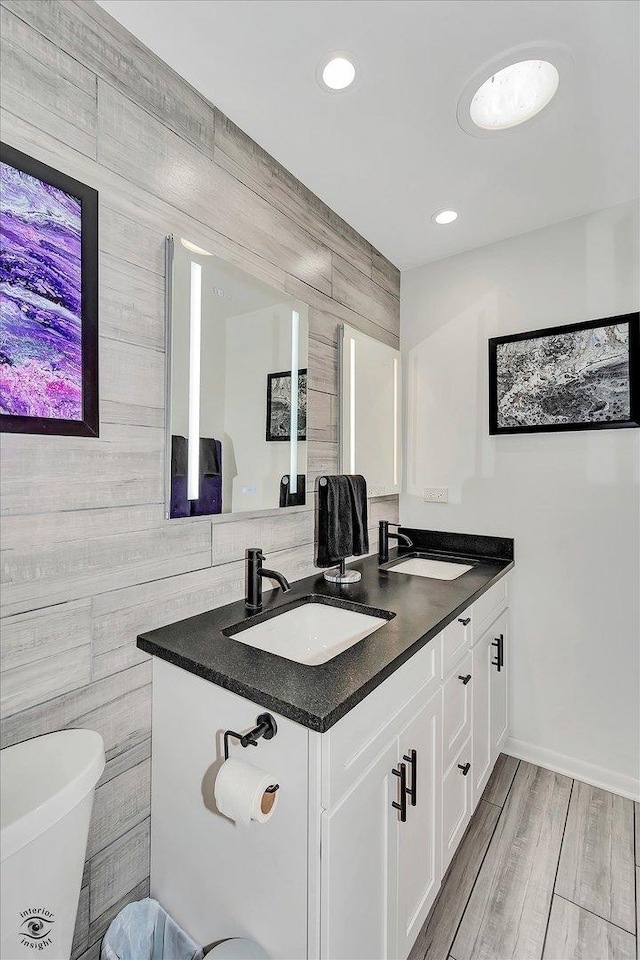 bathroom featuring vanity, wood-type flooring, and tile walls