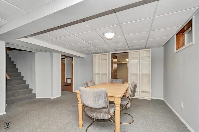 carpeted dining space featuring a drop ceiling