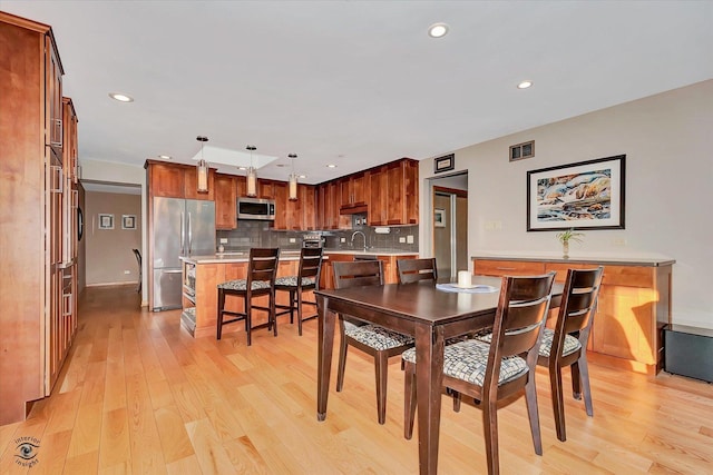 dining space featuring sink and light hardwood / wood-style flooring