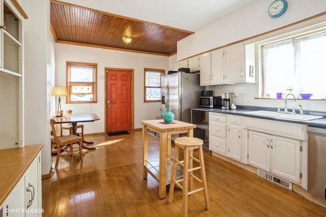 kitchen featuring white cabinets, visible vents, stainless steel appliances, and a sink