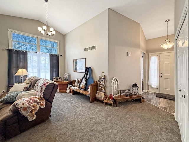 foyer entrance featuring high vaulted ceiling, a chandelier, visible vents, and carpet flooring