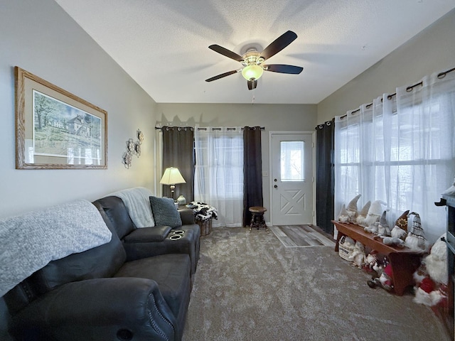 living room featuring carpet floors, ceiling fan, and a textured ceiling