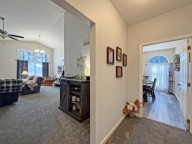 corridor with lofted ceiling, carpet floors, plenty of natural light, and visible vents