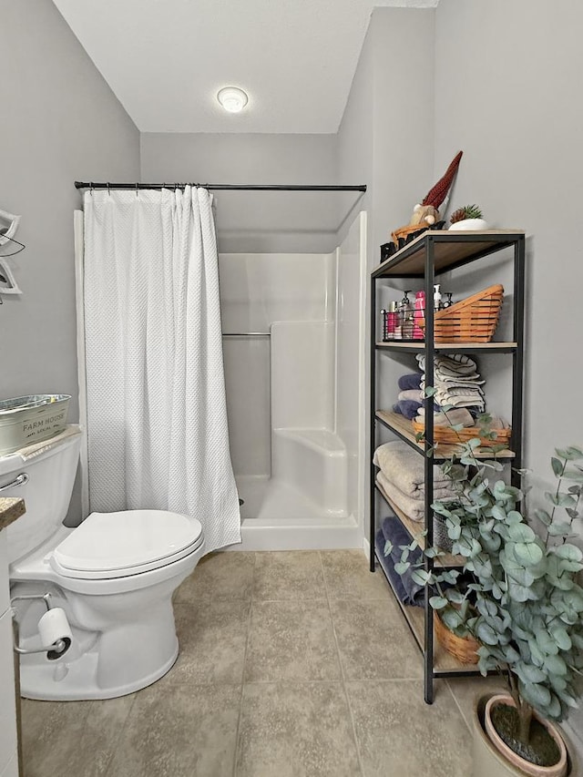 bathroom featuring toilet, tile patterned floors, and a shower with shower curtain