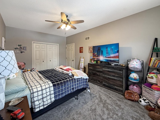 carpeted bedroom featuring a ceiling fan, a closet, visible vents, and a textured ceiling