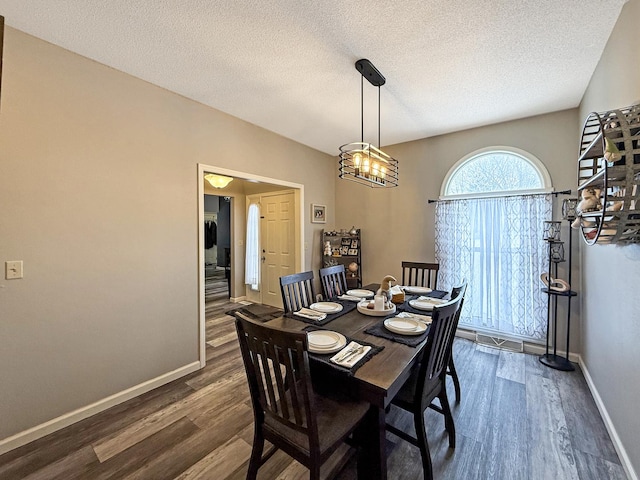 dining area featuring an inviting chandelier, baseboards, dark wood finished floors, and a textured ceiling