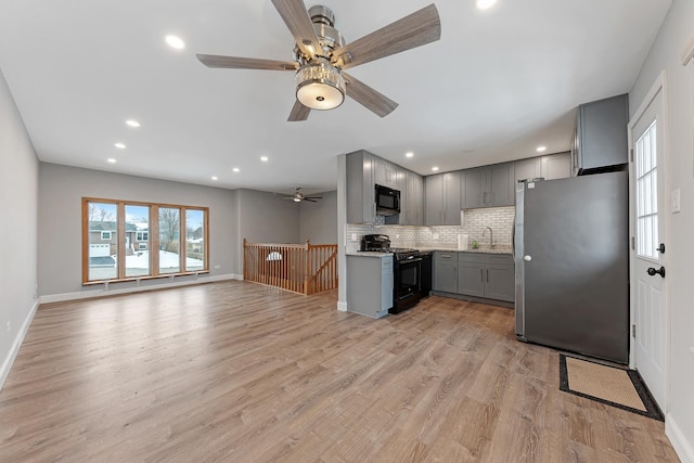 kitchen featuring gray cabinets, sink, decorative backsplash, black appliances, and light hardwood / wood-style flooring