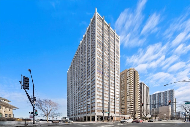 view of building exterior featuring a view of city and fence