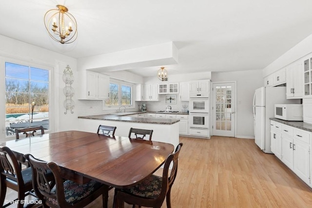 dining space featuring light hardwood / wood-style flooring and a notable chandelier