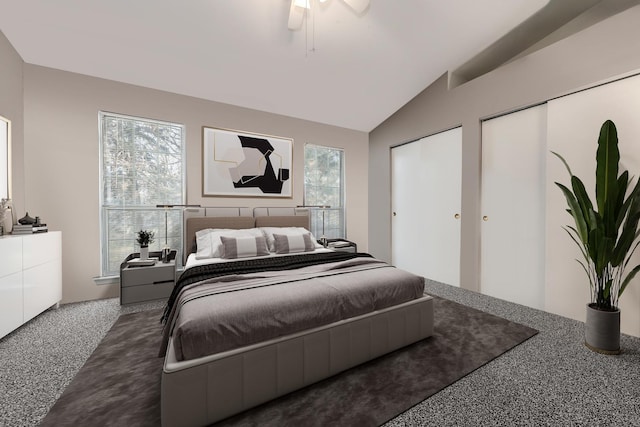 carpeted bedroom with multiple closets, ceiling fan, and vaulted ceiling