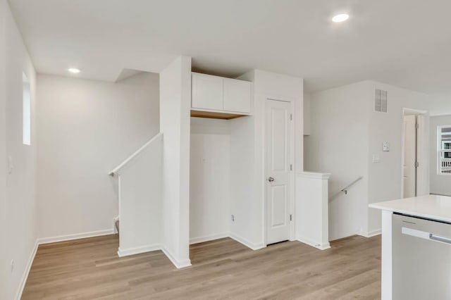 kitchen featuring dishwasher, white cabinets, and light hardwood / wood-style flooring