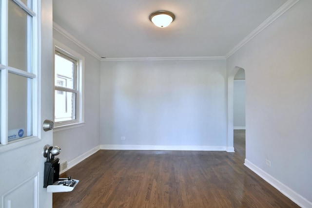 empty room with dark hardwood / wood-style flooring and ornamental molding