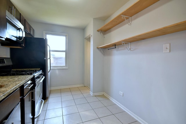 kitchen with light tile patterned flooring, appliances with stainless steel finishes, and dark brown cabinets