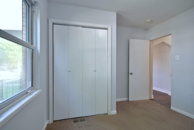 unfurnished bedroom with carpet floors and a closet