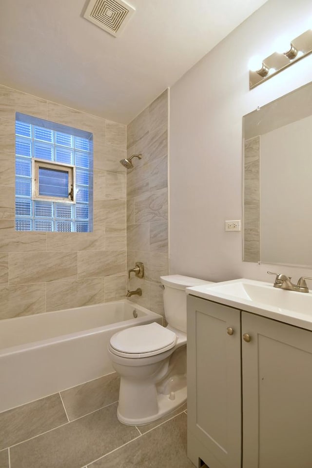 full bathroom with vanity, toilet, tiled shower / bath combo, and tile patterned flooring