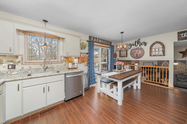 kitchen featuring dishwasher, hanging light fixtures, a sink, and white cabinets