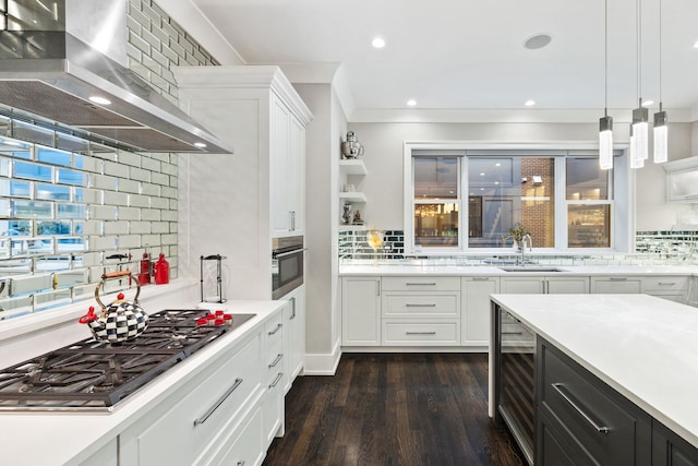 kitchen featuring extractor fan, decorative light fixtures, white cabinets, and appliances with stainless steel finishes