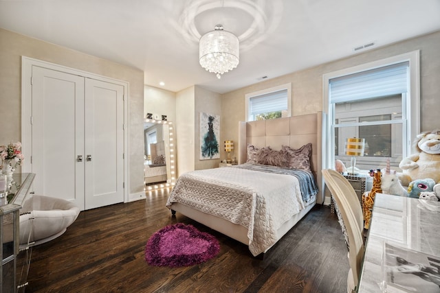 bedroom featuring dark wood-type flooring and a chandelier