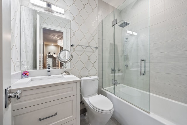 full bathroom featuring vanity, enclosed tub / shower combo, and toilet