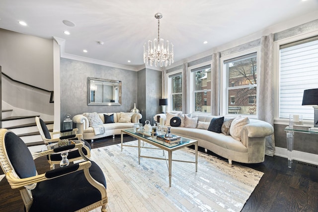 living room with hardwood / wood-style flooring, crown molding, and an inviting chandelier