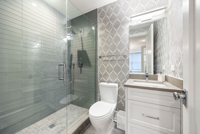 bathroom with tile patterned flooring, vanity, toilet, and a shower with shower door