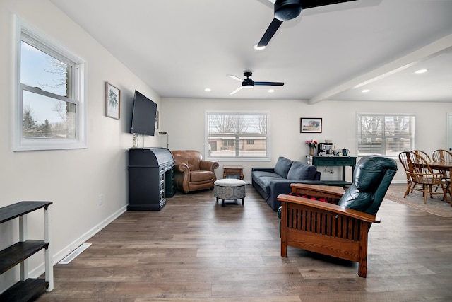 living room featuring beam ceiling, a wealth of natural light, dark hardwood / wood-style floors, and ceiling fan