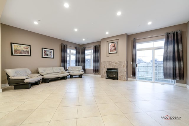 living room featuring a premium fireplace and light tile patterned floors