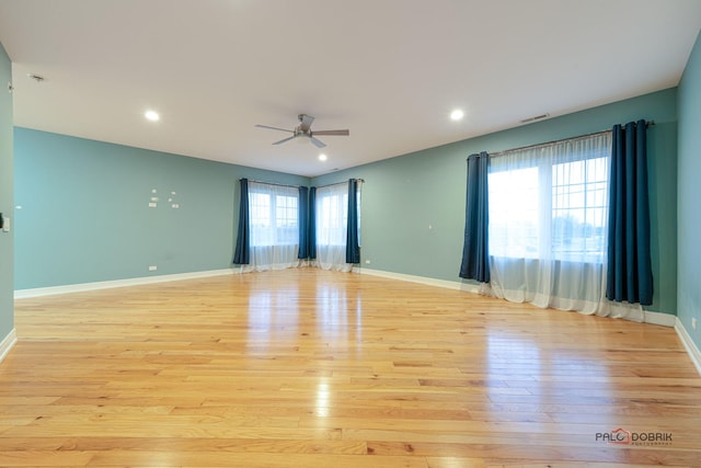 empty room with ceiling fan and light hardwood / wood-style floors