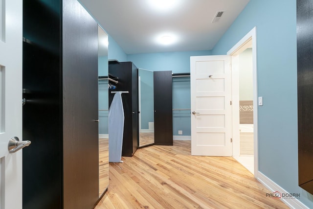 hallway with light hardwood / wood-style floors