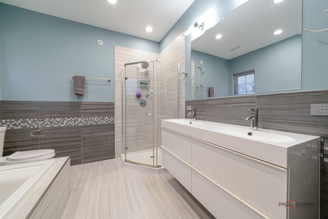 bathroom featuring tile walls, vanity, and an enclosed shower