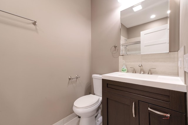 bathroom with vanity, decorative backsplash, and toilet