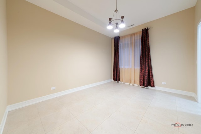 tiled empty room featuring a notable chandelier