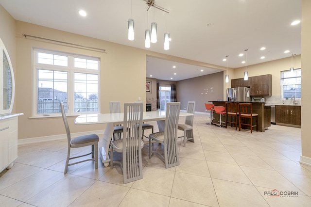 tiled dining room with a healthy amount of sunlight and sink