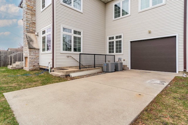 exterior space with a garage and central AC unit