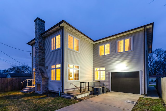 view of front of house with a garage and central air condition unit