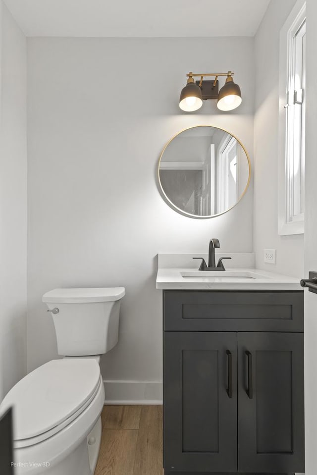 bathroom featuring wood-type flooring, toilet, and vanity