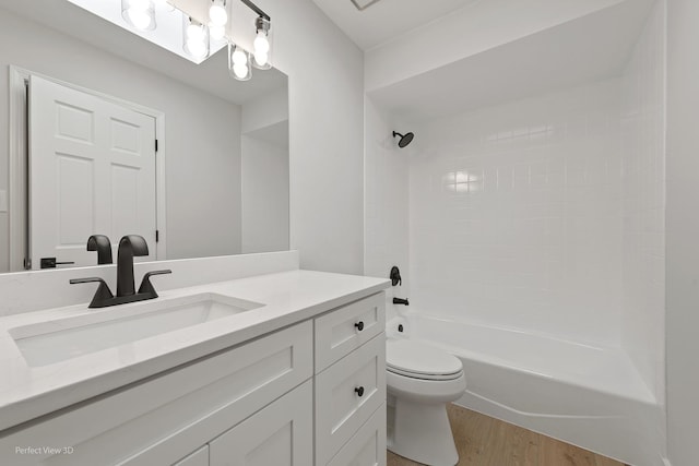 full bathroom with vanity, hardwood / wood-style floors, toilet, and washtub / shower combination