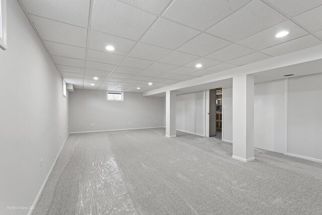 basement with carpet flooring and a drop ceiling