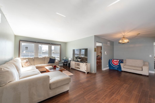 living room featuring dark wood-type flooring and a notable chandelier