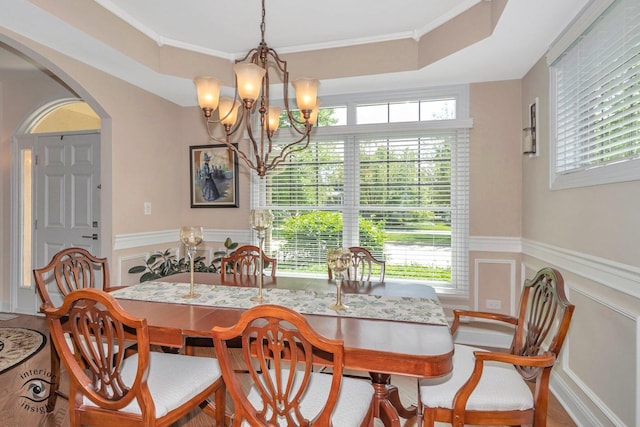 dining room featuring crown molding, a healthy amount of sunlight, and an inviting chandelier