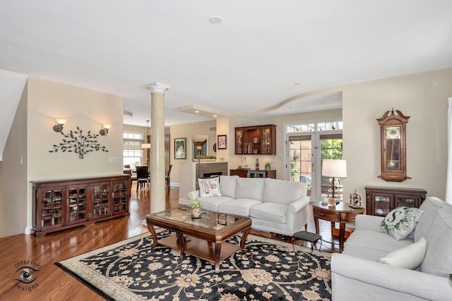 living room with hardwood / wood-style flooring and ornate columns