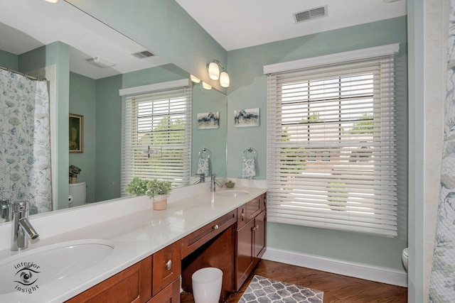 bathroom with hardwood / wood-style flooring, vanity, curtained shower, and toilet