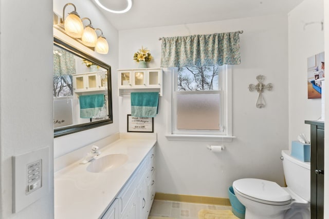 bathroom with vanity, toilet, and baseboards