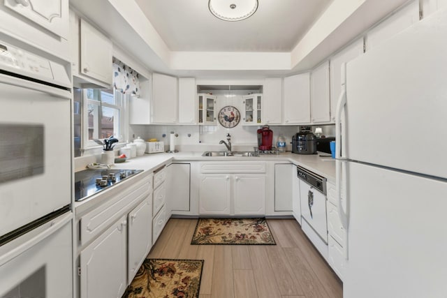 kitchen featuring light countertops, white appliances, white cabinetry, and a sink