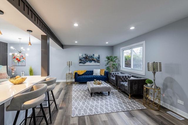 living room featuring a chandelier and dark hardwood / wood-style flooring