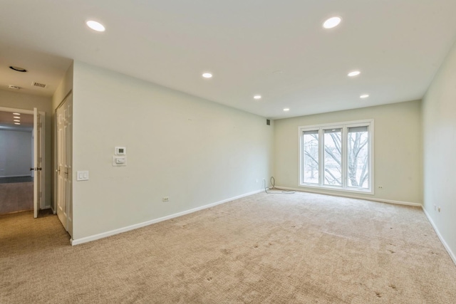 empty room featuring recessed lighting, baseboards, and carpet