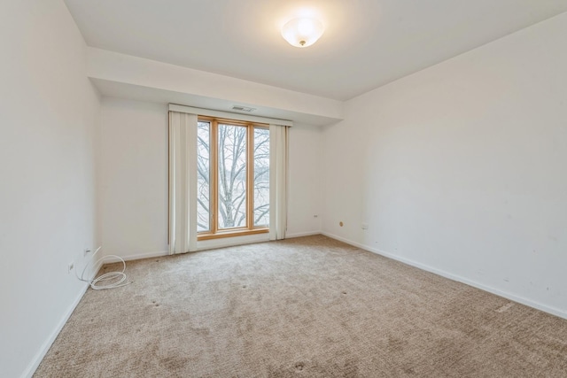 spare room featuring visible vents, baseboards, and carpet