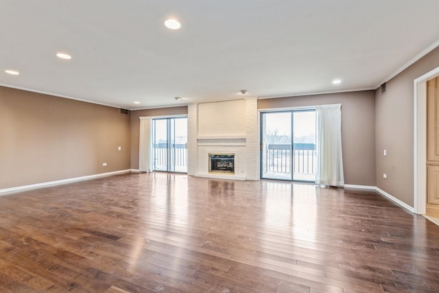 unfurnished living room featuring plenty of natural light, a fireplace, dark wood-type flooring, and baseboards