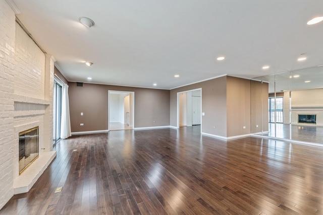 unfurnished living room with crown molding, a fireplace, dark wood-style flooring, and baseboards