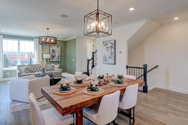 dining room with crown molding, an inviting chandelier, and light hardwood / wood-style flooring